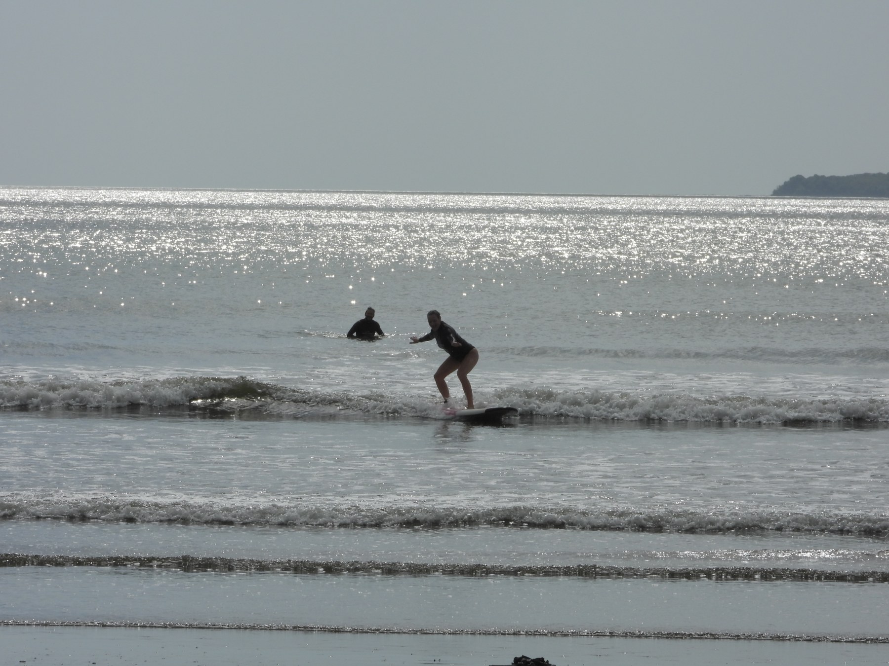 Student standing on a surfboard while riding a wave in Mariato